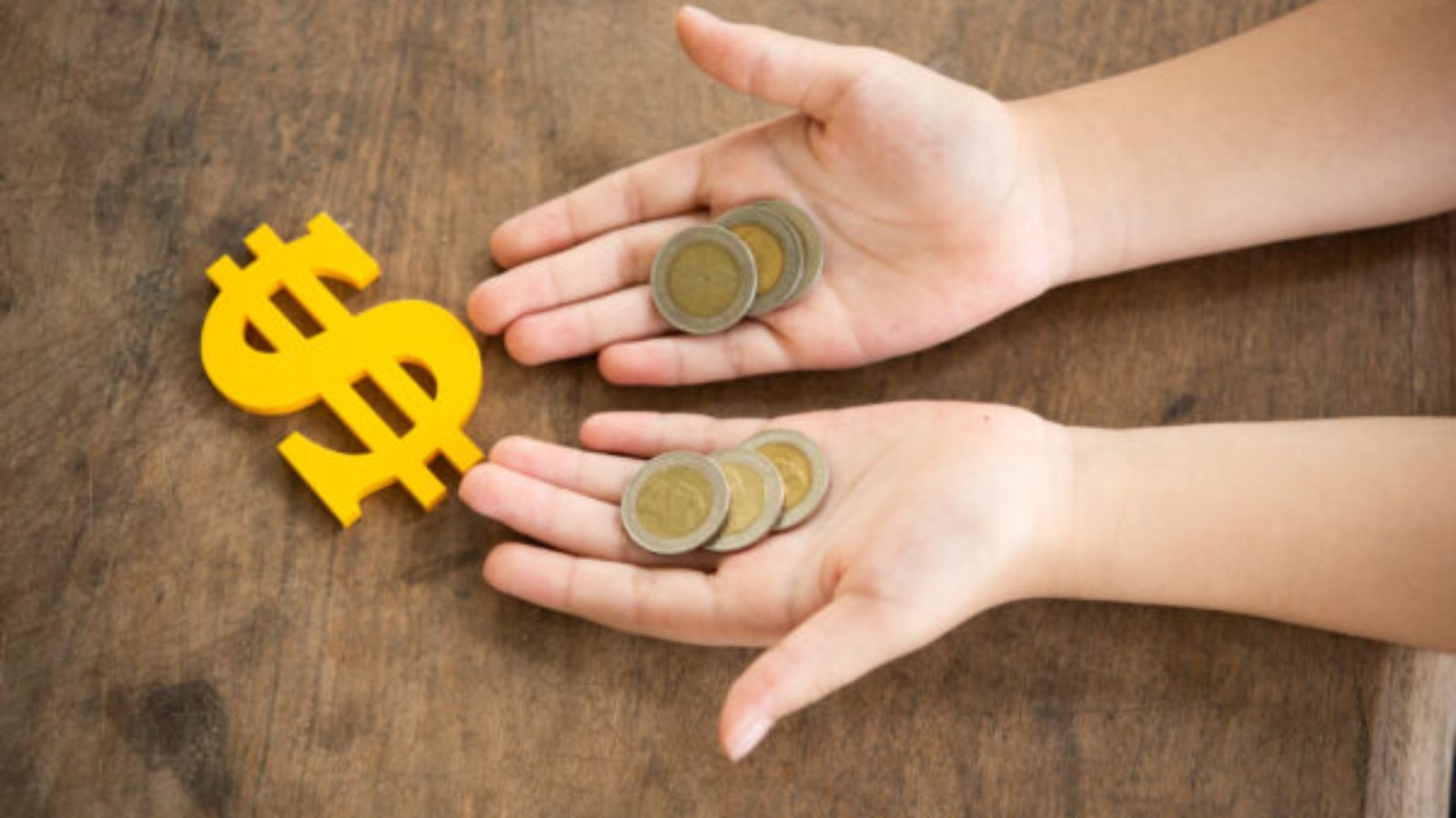 coins on hands child and The yellow dollar symbol on table for the investment or saving of people with differences diversity for insurance, education, safety life for good and stable in future of family